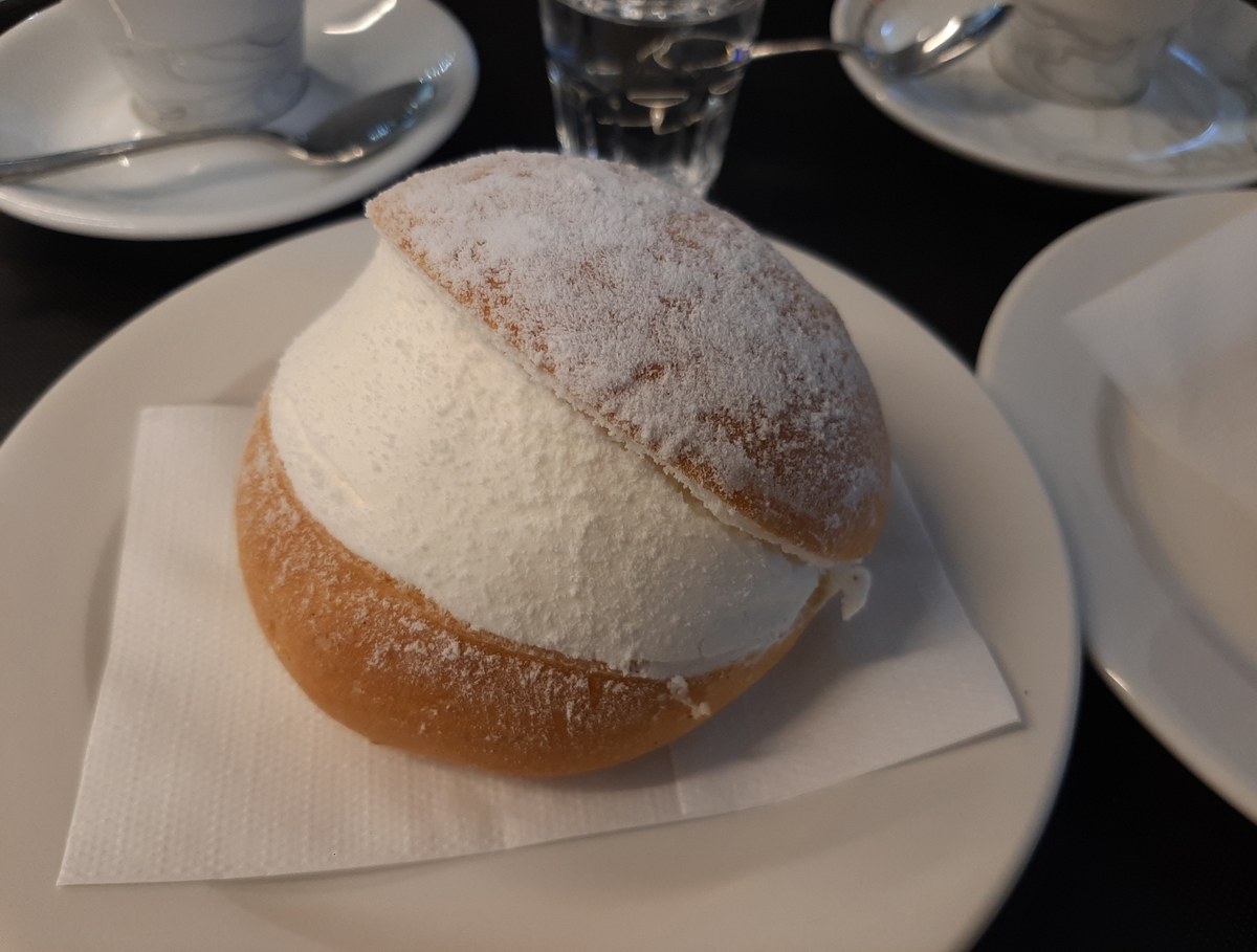 Maritozzo con la panna spolverato di zucchero a velo su un piattino