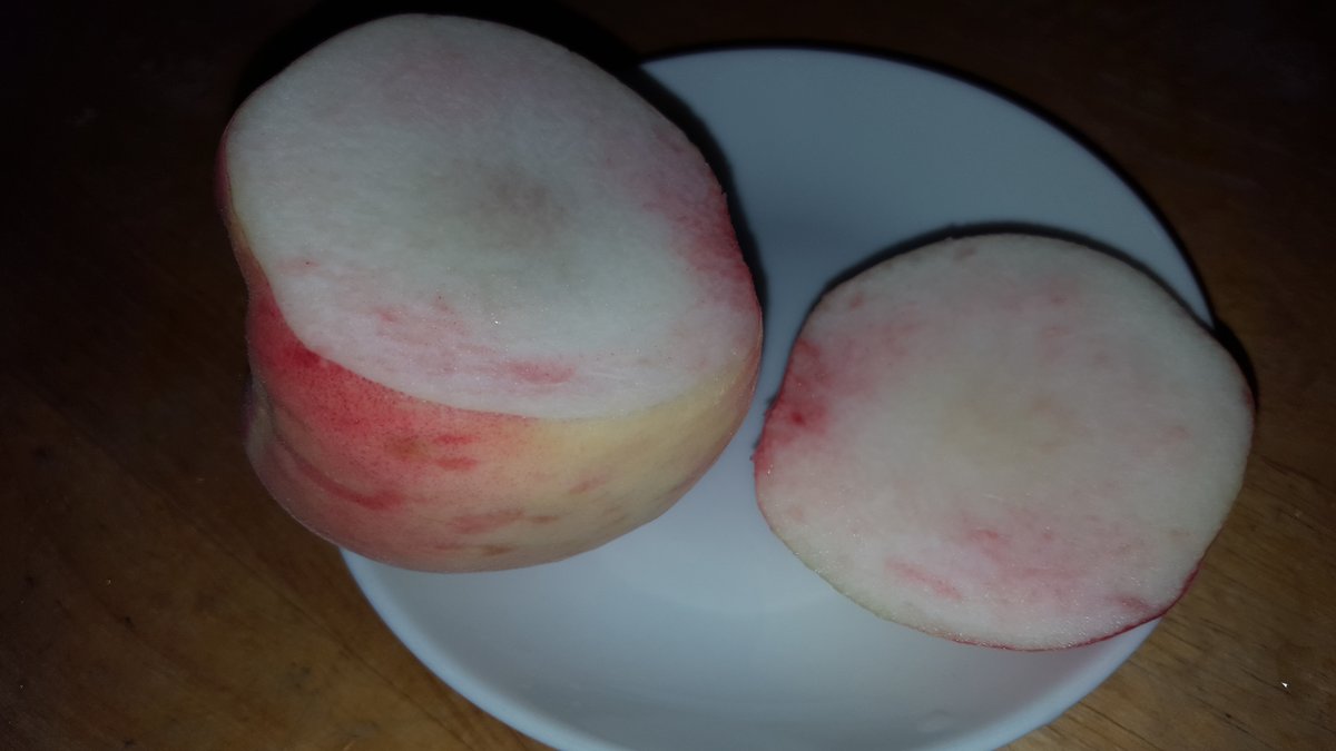 Pesche bianche tagliate a metà su un piatto